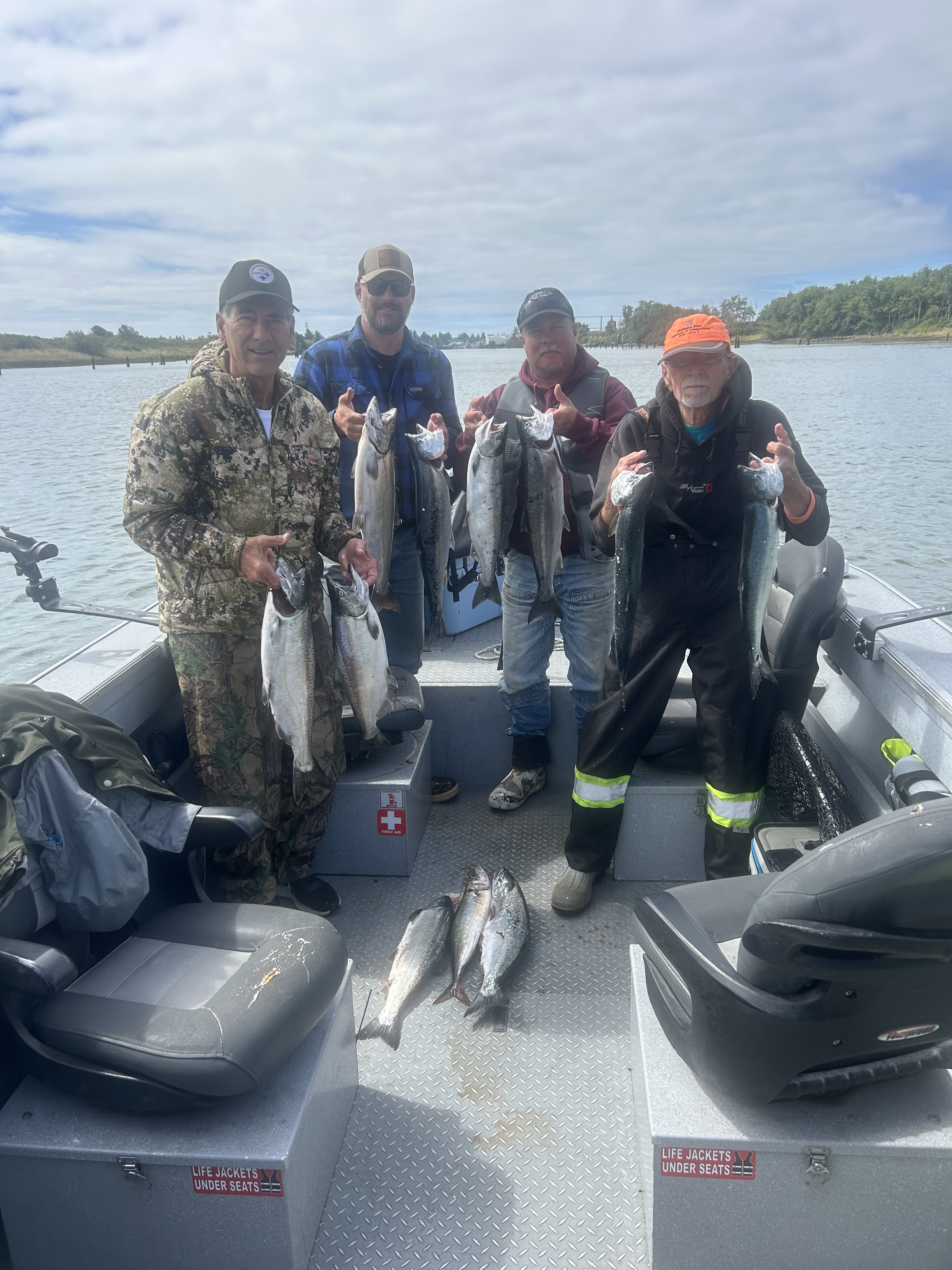 Fishing guests holding salmon on Reese Johnson’s guide boat